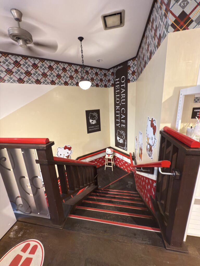 Interior staircase at Otaru Hello Kitty Café with themed wall art and kawaii design, Instagrammable Sanrio café in Otaru Japan