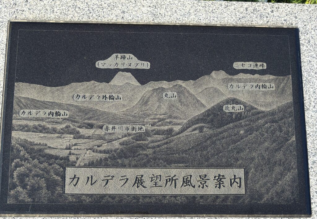 カルデラ展望所の風景案内石碑—羊蹄山(マッカリヌプリ)・丸山・北丸山・内輪山/外輪山・赤井川市街地の位置が分かる図