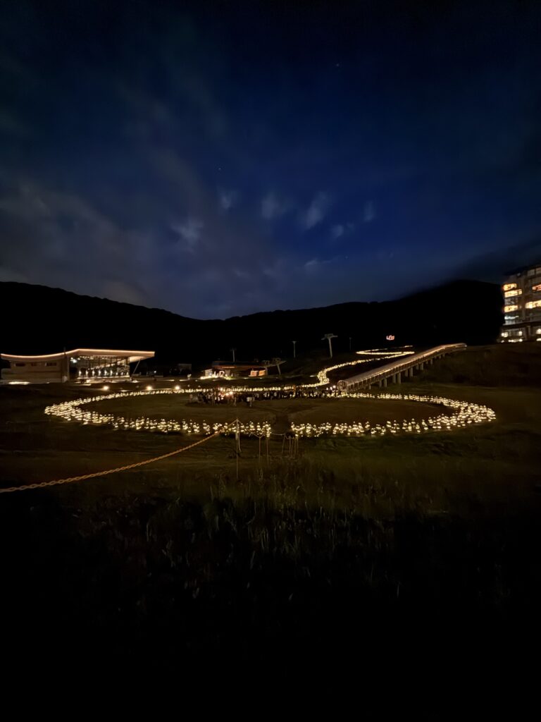 Wide night view of Mountain Lights light rings and walkway from a free viewing area