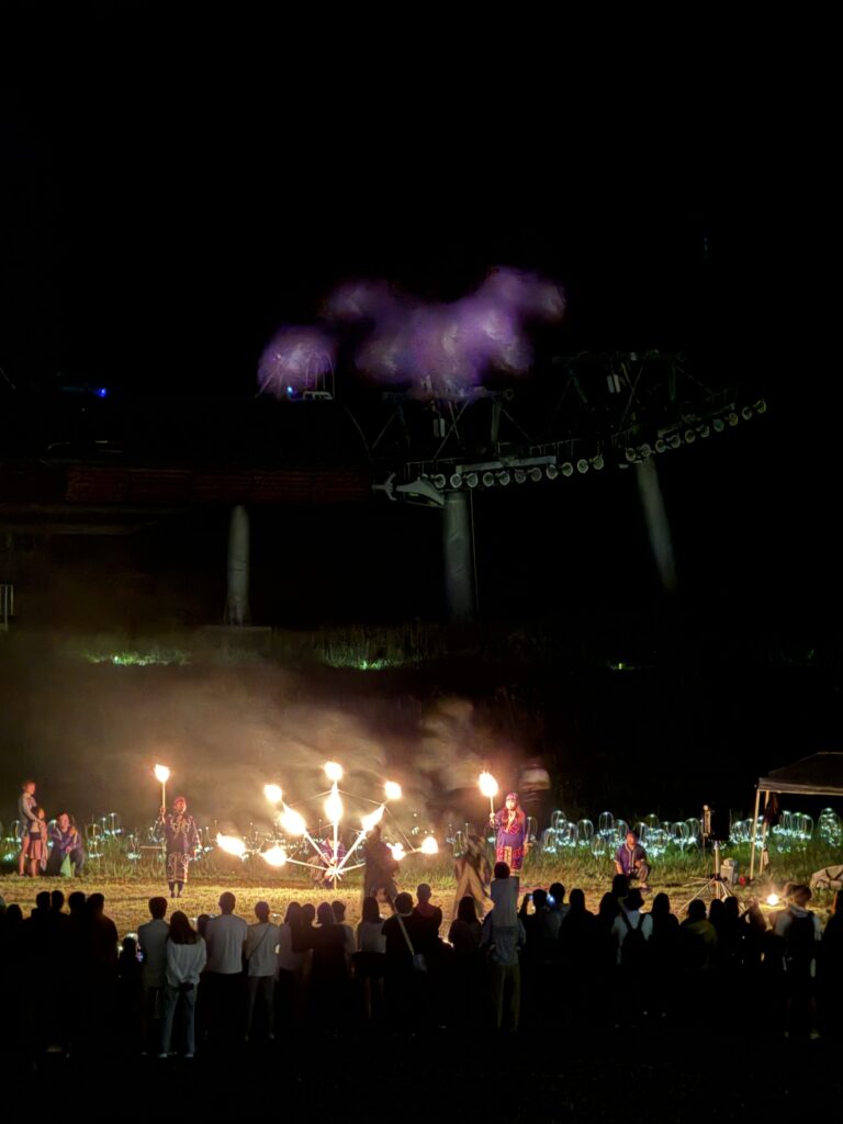 Fire Goddess flame performance at Niseko HANAZONO—audience with ski lift and glowing light installation (2025)