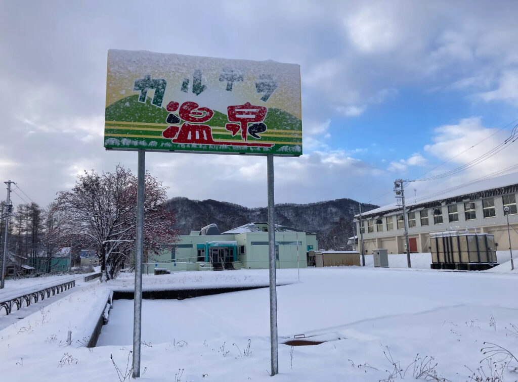 赤井川カルデラ温泉の看板と駐車場。雪が少しある時