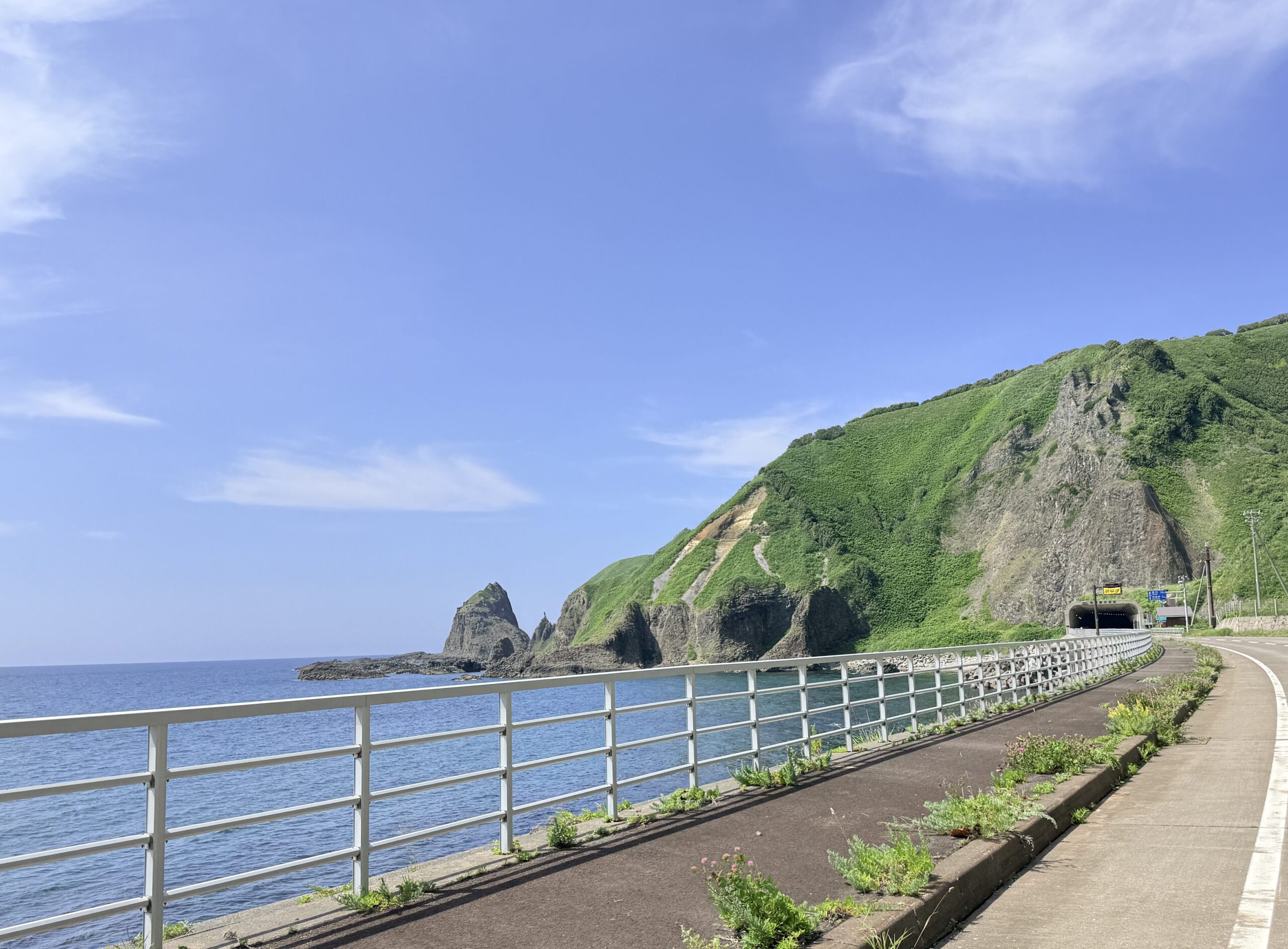 神威岬へ向かうドライブルートから望む青空と積丹ブルー、緑の山々
