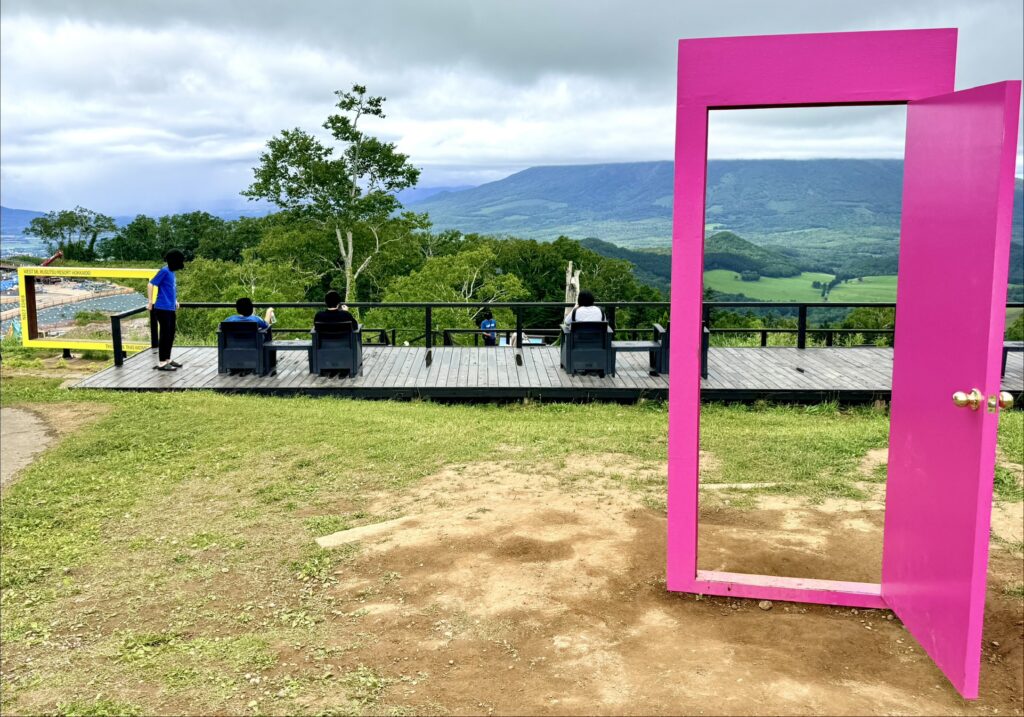  羊蹄パノラマテラスのピンクのドアと夏の山