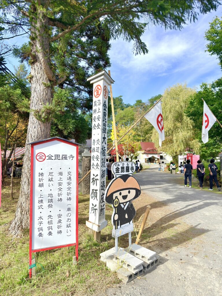 倶知安町の金毘羅寺入口に設置された祈願案内板と秋季例大祭の参拝者