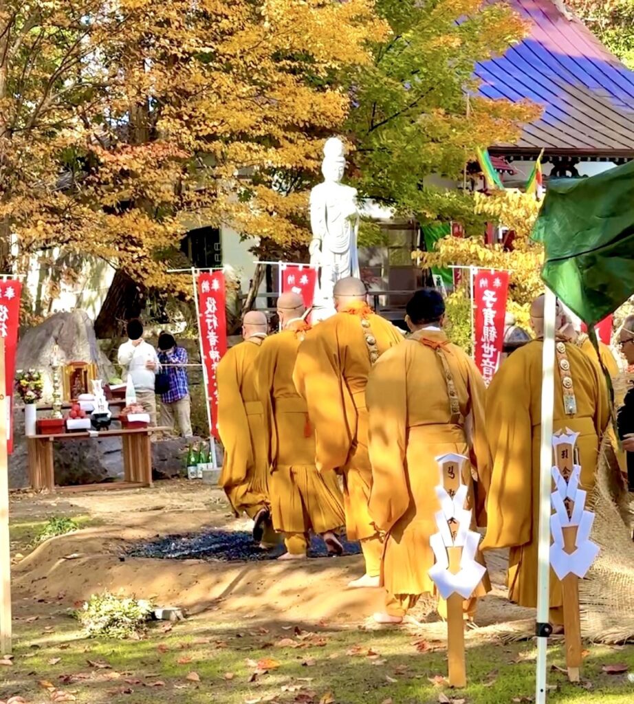 倶知安・金毘羅寺の火渡りの儀で黒くなった炭の上を裸足で歩く僧侶たち