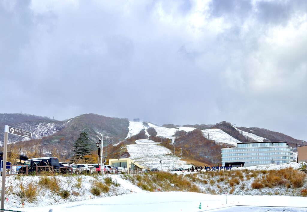 ニセコ東急グラン・ヒラフのNISEKO看板と雪に覆われた山並み